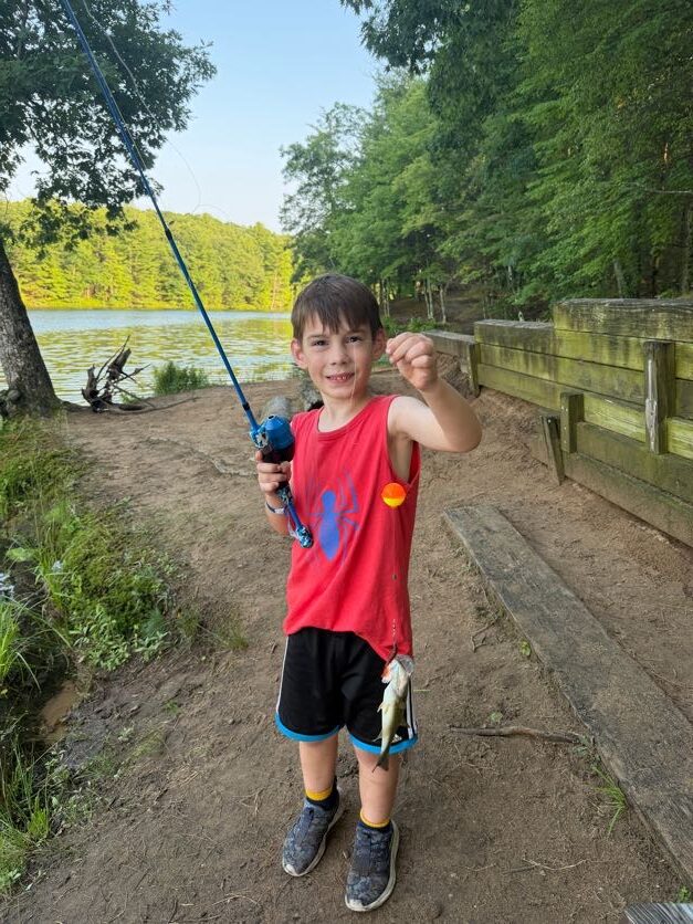 Scout showing a fish caught near the dock