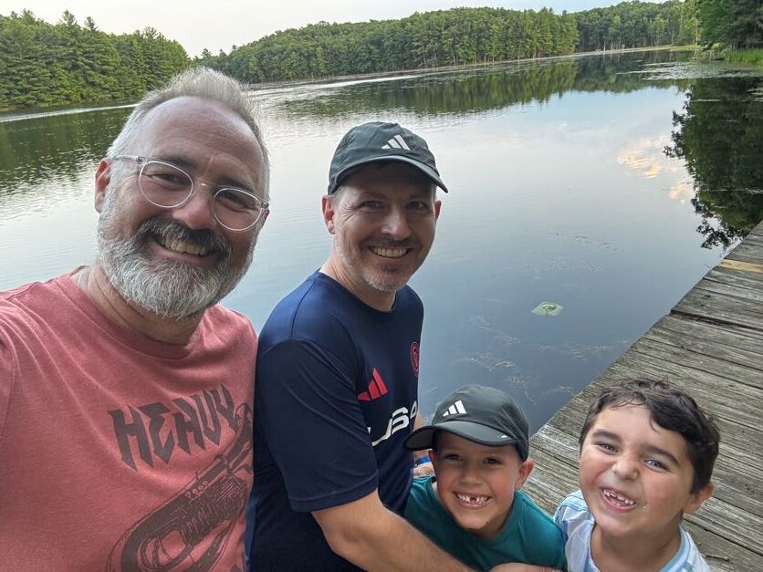 Pack members taking a group photo by the lake