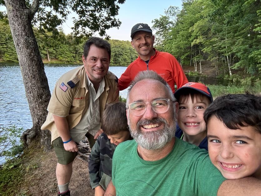 Leaders and Scouts taking a group photo near the water