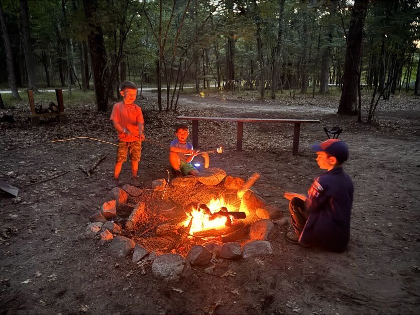 Scouts sitting around a campfire at dusk